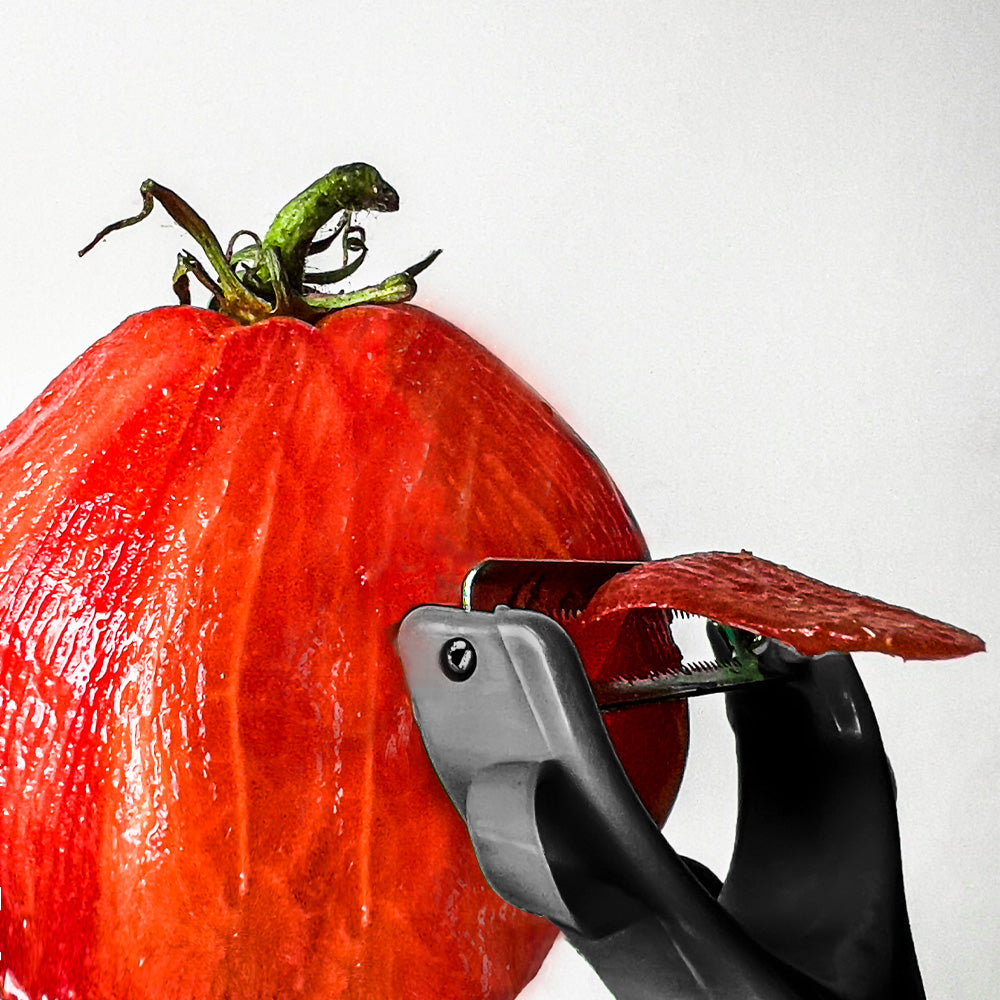 Sparschäler bei der Anwendung beim Schälen von Tomaten